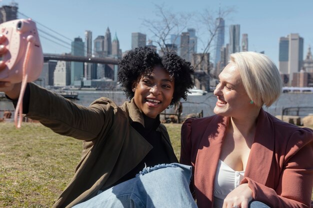 Donne di tiro medio con macchina fotografica fuori