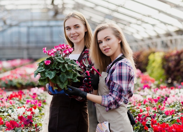 Donne di vista frontale che tengono il vaso di fiori