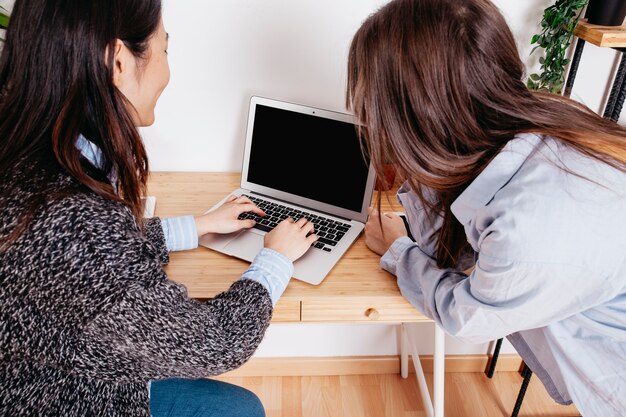 Donne digitando al computer portatile