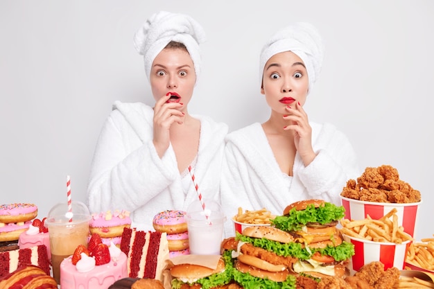 Donne diverse e stordite muoiono di fame per il cibo ricco di zuccheri e grassi mangiano fast food