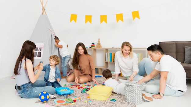 Donne e uomo che giocano con i bambini a casa