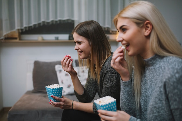 Donne eccitate che mangiano popcorn e guardano film