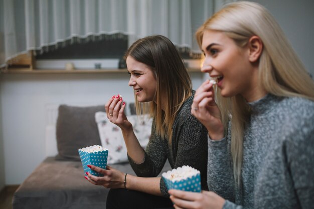 Donne eccitate che mangiano popcorn e guardano film