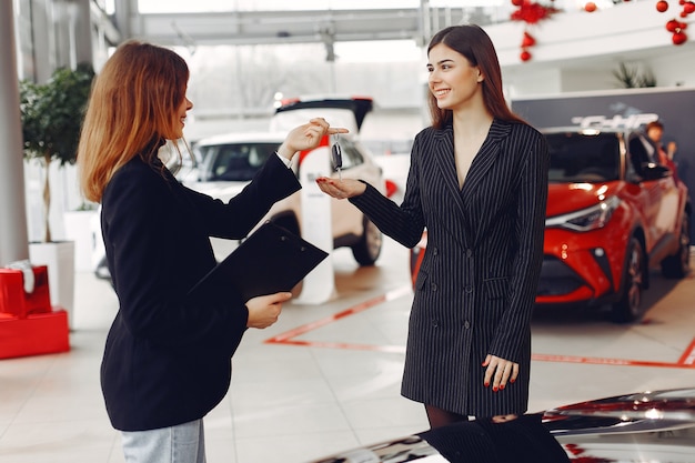 Donne eleganti e alla moda in un salone di auto