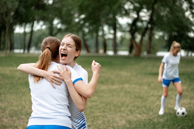 Donne emozionanti che abbracciano all'aperto