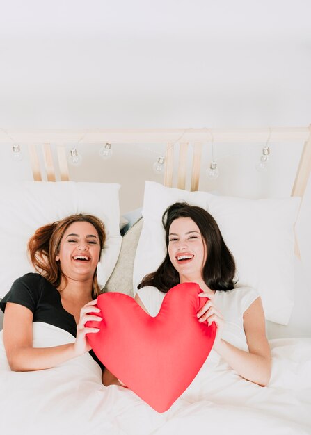 Donne felici con il cuore a letto