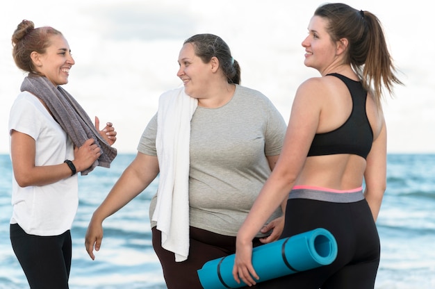 Donne felici del colpo medio alla spiaggia