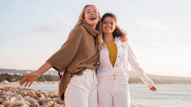 Donne felici del colpo medio in riva al mare