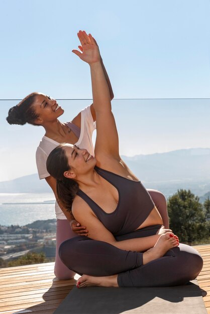 Donne felici del colpo pieno che fanno yoga