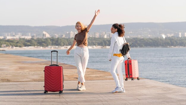 Donne felici del colpo pieno in riva al mare