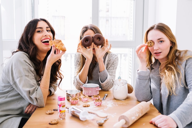 Donne graziose che posano con la pasticceria