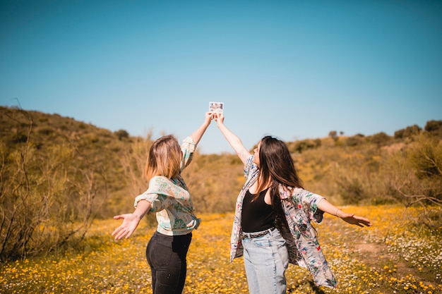 Donne graziose che tengono foto