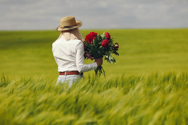 Donne in abiti eleganti in piedi in un campo estivo