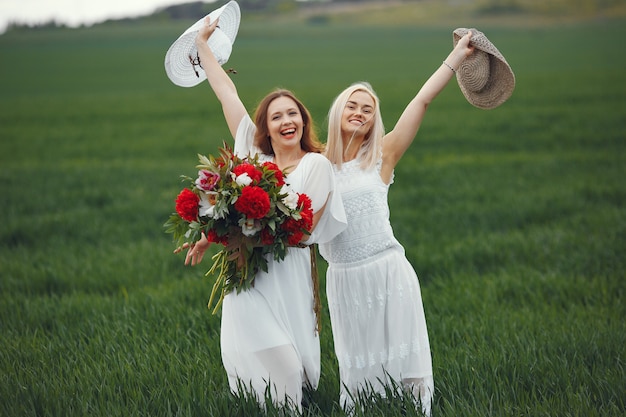 Donne in abito elegante in piedi in un campo estivo