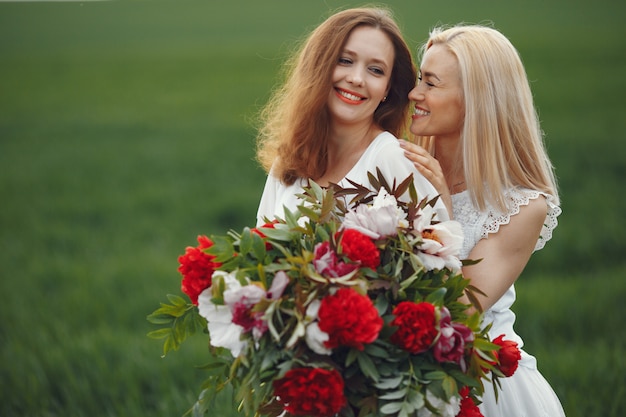 Donne in abito elegante in piedi in un campo estivo