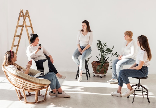 Donne in camicie bianche che hanno una conferenza