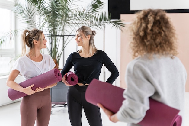 Donne in possesso di tappetini da yoga colpo medio