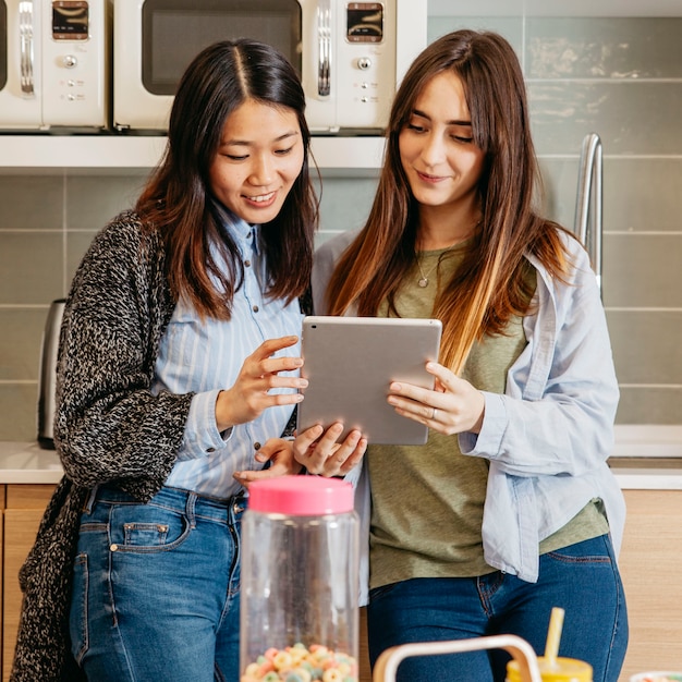 Donne multietniche con tablet in cucina