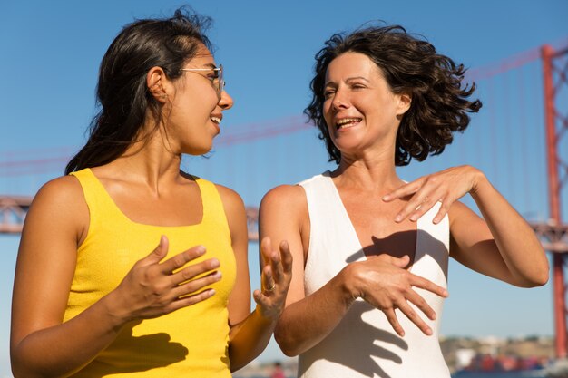 Donne multietniche felici che camminano alla riva del fiume