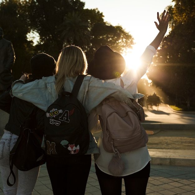 Donne posteriori di vista che camminano durante il tramonto