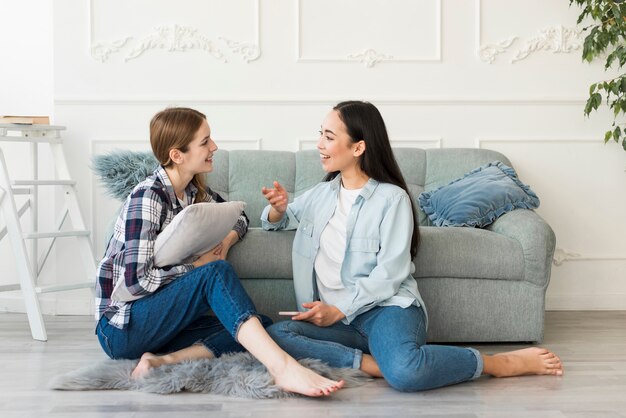 Donne sedute sul pavimento a piedi nudi e parlando animatamente