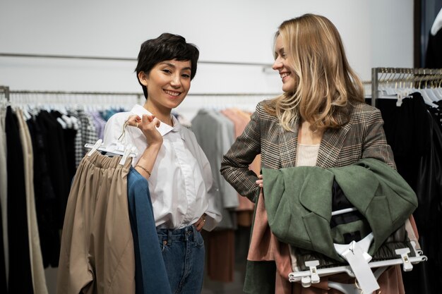 Donne sorridenti a colpo medio allo shopping