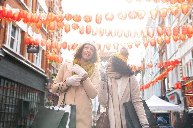 Donne sorridenti a colpo medio che camminano in città