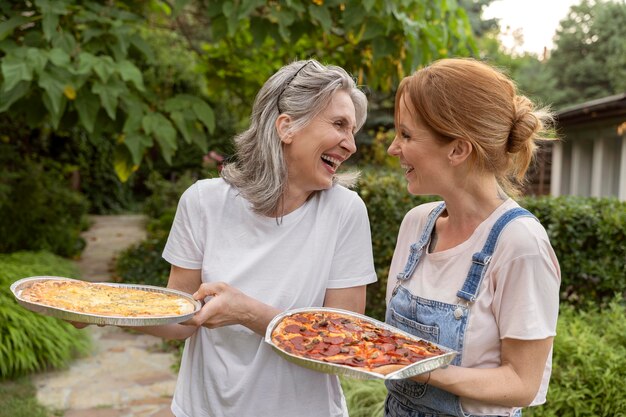 Donne sorridenti a colpo medio con pizza