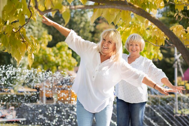 Donne sorridenti a colpo medio nel parco