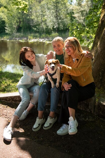 Donne sorridenti a tutto campo con cane carino