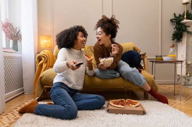 Donne sorridenti a tutto campo con pizza