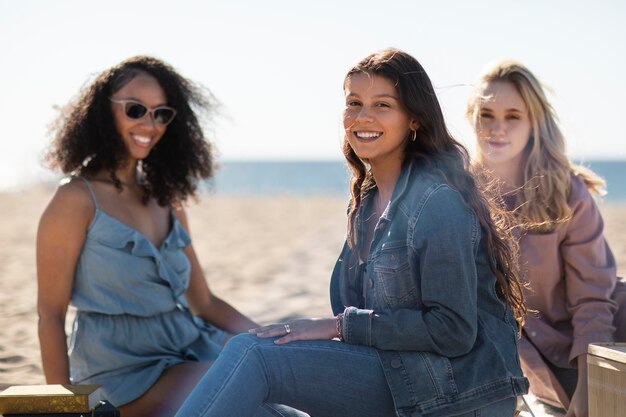 Donne sorridenti del colpo medio alla spiaggia