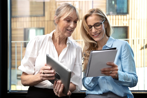 Donne sorridenti del colpo medio che lavorano insieme