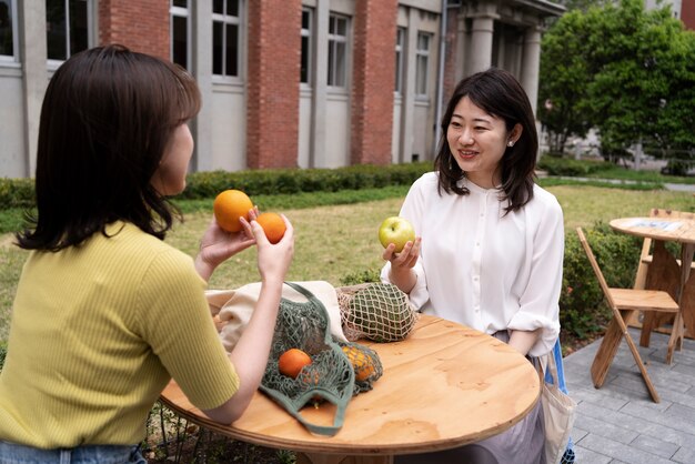 Donne sorridenti del colpo medio che si siedono al tavolo