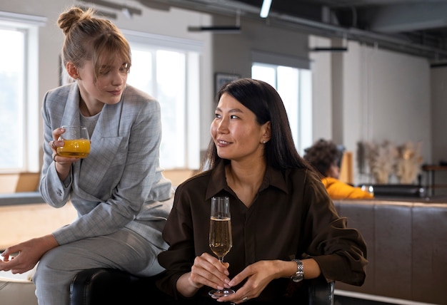 Donne sorridenti del colpo medio che tengono le bevande