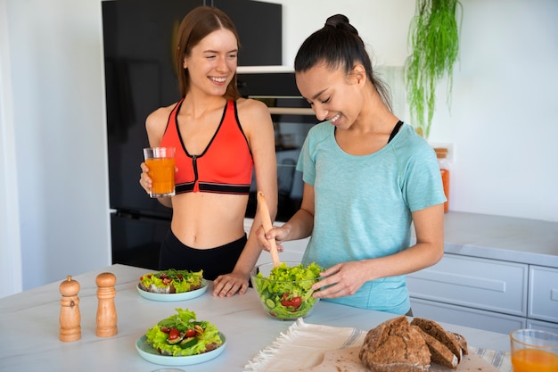 Donne sorridenti del colpo medio con cibo sano