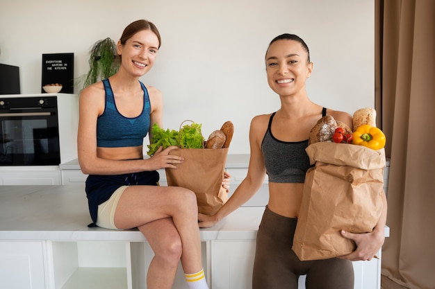 Donne sorridenti di vista frontale con generi alimentari