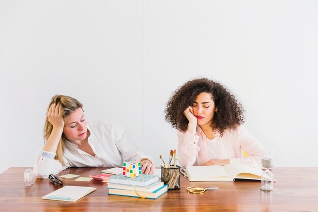 Donne stanche che si siedono alla tavola