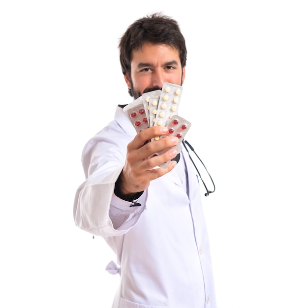Dottore holding pillole su sfondo bianco
