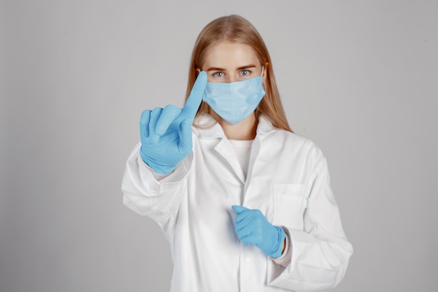 Dottore in una maschera medica. Tema Coronavirus. Isolato sopra il muro bianco
