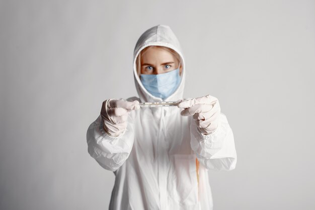 Dottore in una maschera medica. Tema Coronavirus. Isolato su sfondo bianco. Donna in una tuta protettiva.