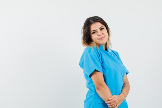 Dottoressa in uniforme blu in posa in piedi e con un aspetto affascinante