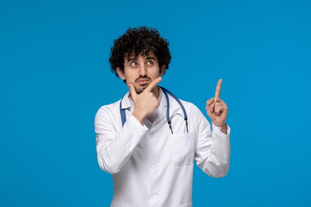 Dottori giorno ricci bel ragazzo carino in uniforme medica pensando e alzando lo sguardo