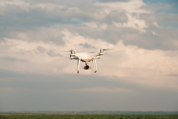 Drone bianco in bilico in un cielo blu brillante