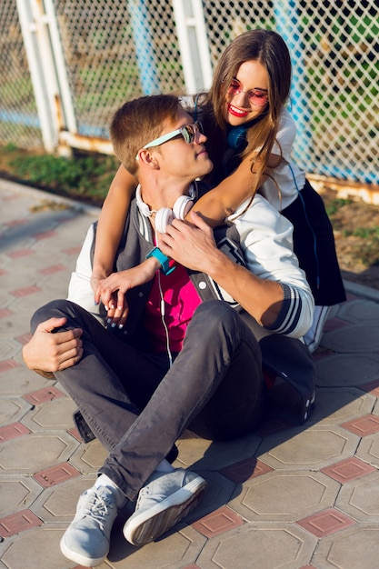 Due adolescenti moderni abbastanza giovani in posa all'aperto in abito casual elegante