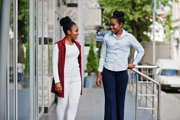 Due amiche alla moda afroamericane poste all'aperto di steets city