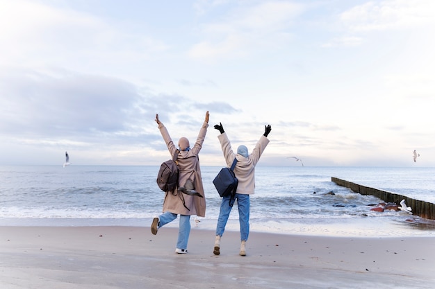 Due amiche musulmane che camminano sulla spiaggia durante il viaggio