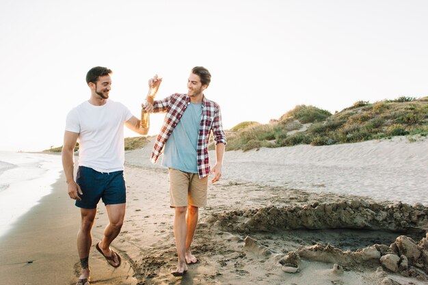 Due amici che camminano sulla spiaggia