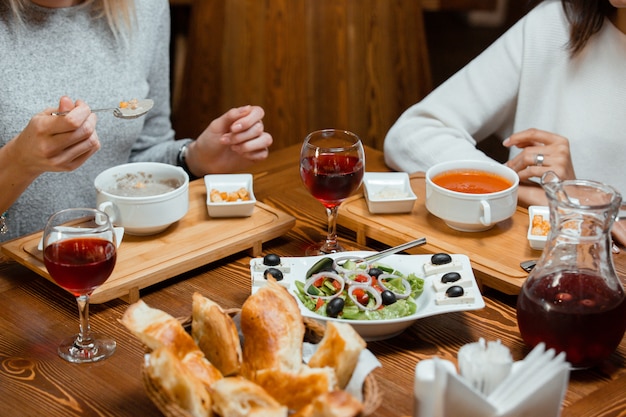 due amici che mangiano zuppa e insalata mentre bevono il compot