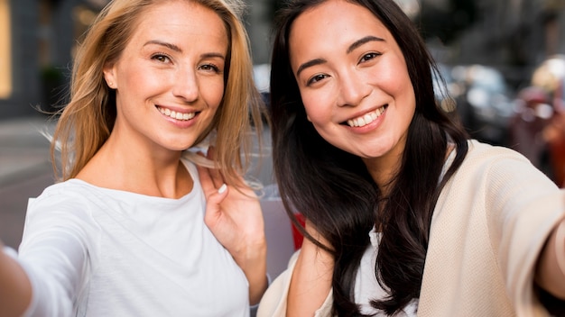 Due amici che prendono un selfie insieme dopo una sessione di shopping